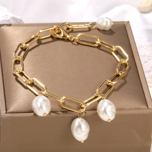 Detail of baroque pearl charms on a polished gold rectangular link chain bracelet