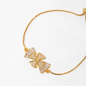Detailed shot of gold plated cross bracelet with white zircon butterfly charms and slider