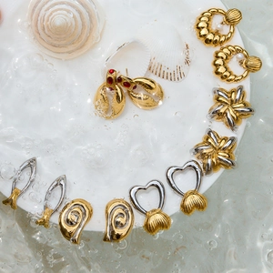 Détails de boucles d'oreilles en forme de coquillage et d'étoile de mer sous l'eau claire