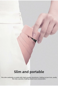 Slim pink 6-fold umbrella only 3cm thick being tucked easily into a pocket