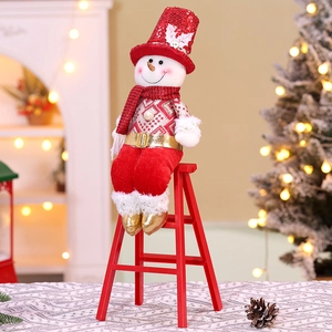 Detail of a Christmas snowman doll in red sequins hat sitting on a decorative wood ladder