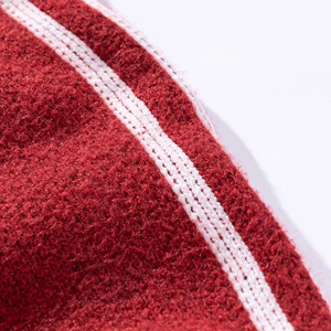 Makroaufnahme von rotem Strickstoff mit weicher Textur und weißen Streifendetails