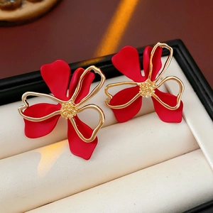 Macro shot of French vintage red flower earrings with gold hollow frame in a jewelry box