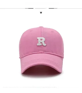 Detailed front view of pink cotton baseball cap featuring 3D embroidered white R letter