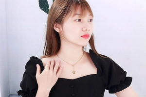 Detail of elegant gold heart pendant necklace on model with vintage titanium steel links