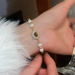 Vue macro d'un bracelet de style vintage avec pierres oeil de tigre et perles blanches