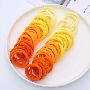 Detail of high-elastic seamless hair ties in vibrant orange and yellow gradient colors