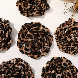 Detailansicht von Kamelienblüten aus Stoff mit Leopardenmuster für Haarschmuck und Broschen