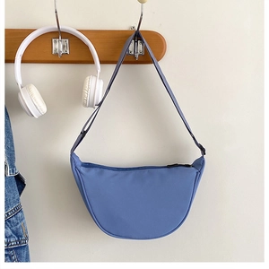 Détail en gros plan d'un sac porté épaule croissant en nylon uni élégant et décontracté.