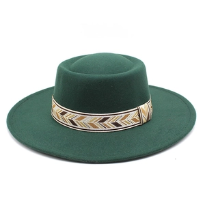Detail of dark green wide brim wool fedora hat with geometric patterned woven band