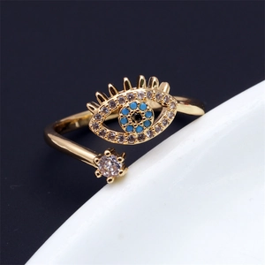 Close-up of golden evil eye ring with blue and white zircon stones and adjustable band