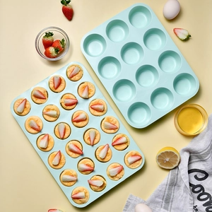 Blue 12 and 24 cup silicone muffin pans with baked mini cakes on a light background