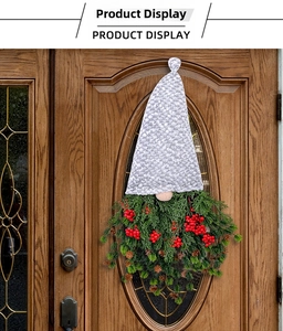 Detail showing Christmas faceless gnome wreath with red berries and pine cones on a wooden door