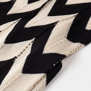 Nahaufnahme von schwarz-beige gestricktem Wellenmuster mit feiner Durchbruchstruktur
