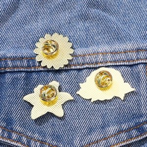 Golden flower enamel brooch pin butterfly clasp backing on blue denim fabric