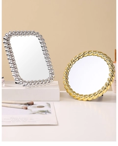 Detail of vintage gold round and silver rectangular makeup mirrors with twisted metal frames