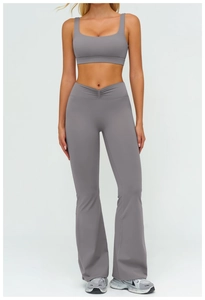 Dettaglio del set yoga grigio con vita a incrocio a V e pantaloni a zampa elasticizzati