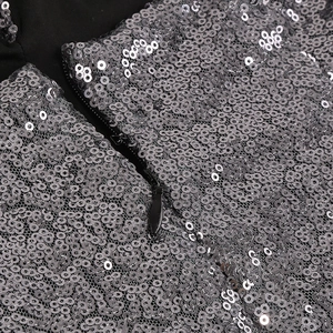 Vue détaillée des paillettes argentées denses et de la fermeture éclair noire de la robe