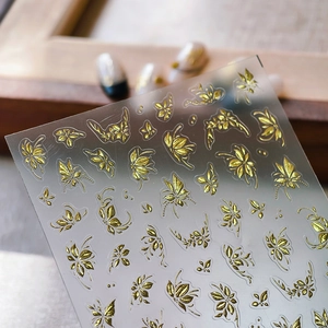 Elegant gold bronzing butterfly and leaf nail art stickers on a clear backing sheet