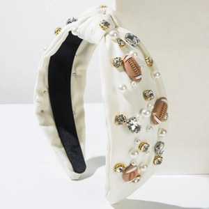 Detail of white knotted headband with sparkling rhinestones, pearls and rugby charms