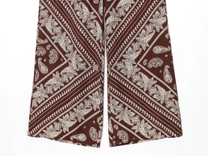 Detailed view of brown paisley print wide-leg trousers with high-quality fabric texture