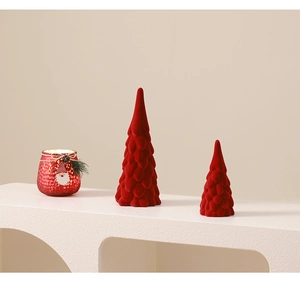 Close-up of red flocked ceramic Christmas trees with textured scale patterns on white stand