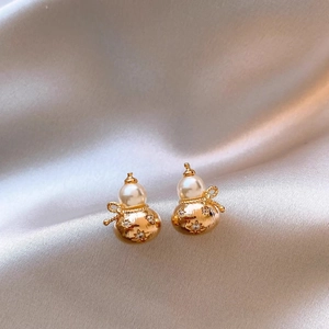 Elegant gold gourd stud earrings with pearls and crystals on champagne silk background