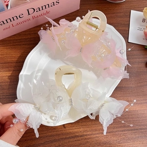 Fairy style butterfly hair claw clip with pearls and rhinestones on a ceramic plate