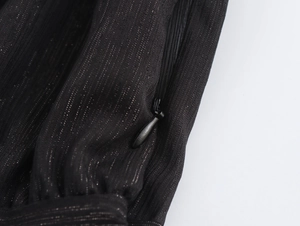Détail du tissu en mousseline noire scintillante avec une fermeture éclair invisible