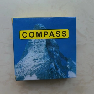 Close-up of blue square compass gift box with snow mountain design and COMPASS logo