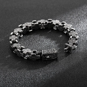 Macro shot of stainless steel cross bracelet with unique bark texture and silver-grey finish