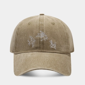 Détail de la broderie d'hirondelle blanche sur casquette de baseball en coton lavé kaki