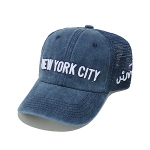 Dettaglio del ricamo New York City su cappellino trucker blu lavato con rete traspirante