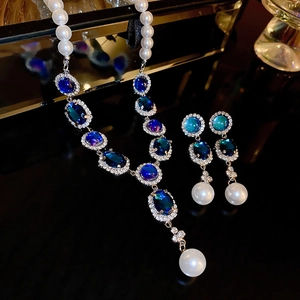 Détail de l'ensemble collier et boucles d'oreilles argentés avec pierres bleues et perles