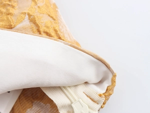 Detailansicht des goldenen Jacquardstoffs und verdeckten Reißverschlusses am Top