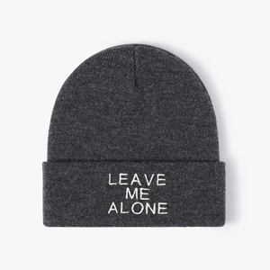 Close-up of LEAVE ME ALONE embroidery on thick dark grey knitted beanie hat