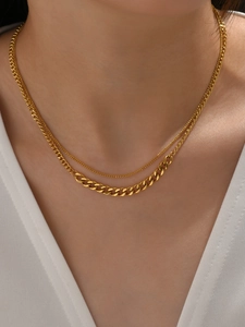Detail of layered gold titanium necklace featuring a bold Cuban link and sleek thin chain