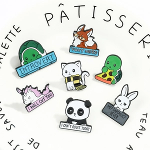Detailed close-up of colorful enamel animal pins with funny quotes on a ceramic plate