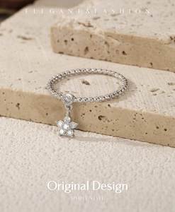 Detailed macro view of S925 sterling silver ring with flower star pendant on stone surface