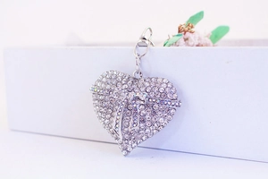 Close-up of silver heart keychain with pavé rhinestones and a delicate bow detail