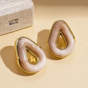 Detail of vintage teardrop earrings with gold rim and beige marble resin inlay