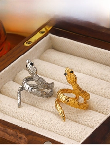Detail shot of gold and silver snake rings with textured scales on a jewelry box display