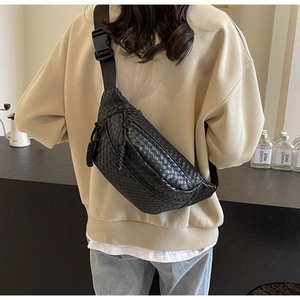 Detail of black woven PU leather chest bag with zipper and drawstring on a model