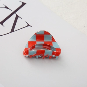 Detail view of red and light blue checkerboard hair claw clip with acetate finish