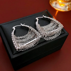 Elegant silver tassel hoop earrings with sparkling rhinestones on a leather background