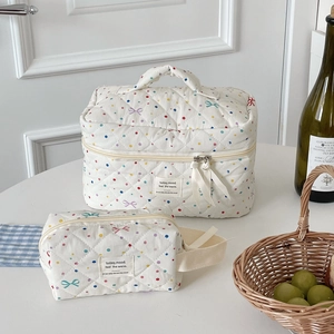 Detailed set of white quilted cosmetic bags with colorful polka dots and bow patterns