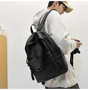 Side view of black faux leather backpack on model showing large capacity and texture