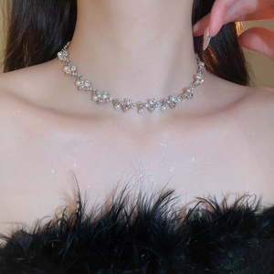 Close-up of pearl and pink rhinestone heart necklace on model neck in soft lighting