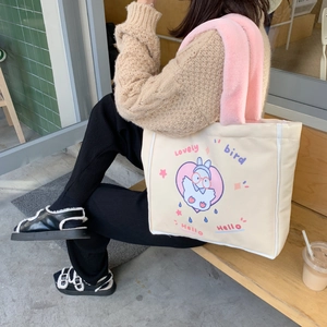 Detail einer süßen Cartoon-Vogel Canvas-Tasche mit rosa Plüschgriffen im Freien