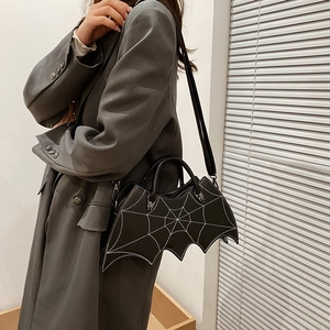 Detail of black PU leather bat bag with spider web embroidery and metal spider accent